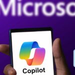 Microsoft Copilot app running on a phone with Microsoft logo in background