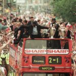 Manchester United – the stars of new Amazon MGM Studios documentary 99 – celebrate winning the treble as the jubilant team make their way through Manchester during an open top bus parade. Teddy Sheringham and Dwight Yorke on 27th May 1999