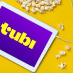 Tubi on a tablet with headphones and popcorn nearby