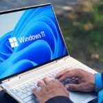 Man typing on Windows 11 laptop