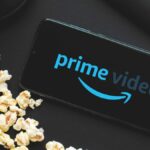 Prime Video app on a phone near popcorn and headphones