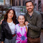 Francesca (played by Eleonora Facchini) and William (Darrin Rose) are pictured either side of a beaming Lucy (Kensington Tallman) who wears a pink and white tie-dye top