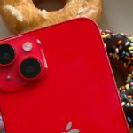 iPhone shown over donuts in bright red color