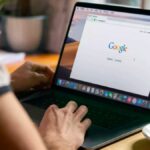 person at desk on laptop accessing google