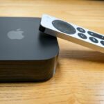 The Apple TV 4K (2022), with the Siri remote propped on its right side.