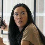 Ali Wong as Amy, pointing a gun at an iPhone in episode 102 of Beef