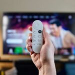 Google TV remote in front of TV