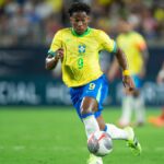 Endrick dribbles the ball for Brazil in the standard yellow shirt and blue shorts first strip.