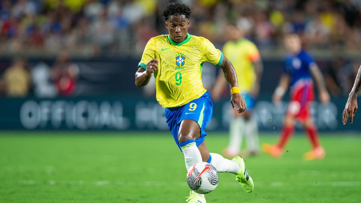 Endrick dribbles the ball for Brazil in the standard yellow shirt and blue shorts first strip.