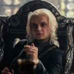 Aegon II (Tom Glynn-Carney) sitting in a chair in the Small Council room in