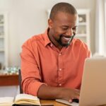 Man sitting at table using laptop