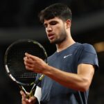 Carlos Alcaraz inspects his racket on-court at the French Open 2024