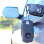 A Tile Pro Bluetooth key finder on a set of keys in a car door