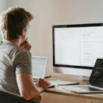 Person looking at three computer screens