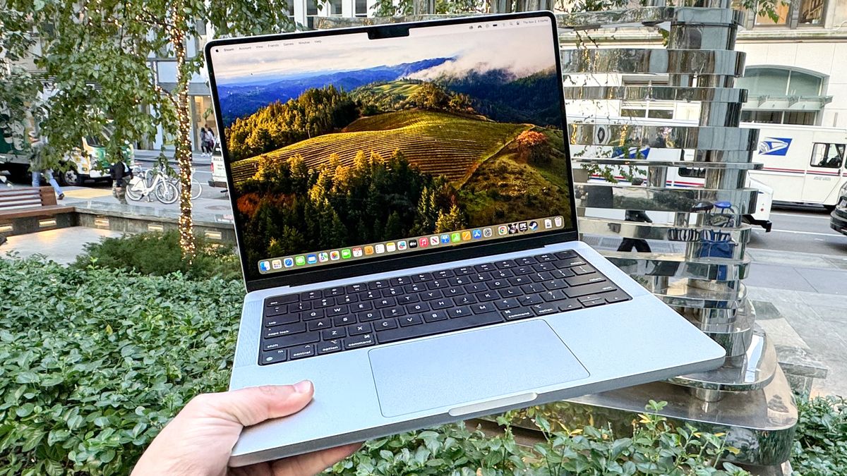 MacBook Pro 14-inch M3 holding in air open