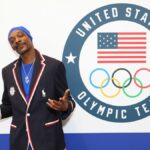 Snoop Dogg poses by the Team USA logo for the Paris 2024 Summer Olympics