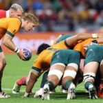 Australia scrum half, in yellow and green, puts the ball into the scrum during Australia vs Wales.