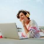 A woman on the beach with a laptop