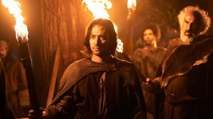 Isildur (Maxim Baldry) holds a burning torch in