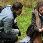 Bryce and Mireya crouch down in the forest to examine samples in a scene from Expedition Bigfoot season 5