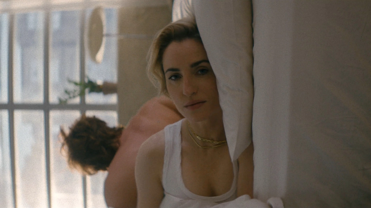 Zoe Lister-Jones as Mae, waking up in bed in comedy Slip