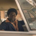 Kevin Hart in a car in a 1970s suit as Chicken Man in Fight Night: The Million Dollar Heist.