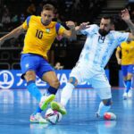 Pito of Brazil (L), in a yellow and blue kit, battles for possession with Pablo Taborda of Argentina, in a blue and white striped kit, during a Futsal World Cup game.