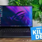 The Asus ROG Zephyrus G16 (2024) pictured sitting on a desk with the &quot;Tom's Guide Killer Deal&quot; badge