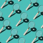 Repeating pattern of magnifying glasses on a turquoise background