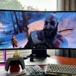 God of War Ragnarök with Kratos smiling on a Samsung Odyssey OLED G9 gaming monitor