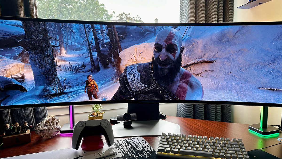 God of War Ragnarök with Kratos smiling on a Samsung Odyssey OLED G9 gaming monitor