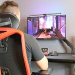 A person sitting in the Herman Miller Vantum gaming chair while playing games at a desk