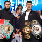 Artur Beterbiev and Dmitry Bivol stand together with their light-heavyweight championship belts.