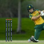 Anneke Bosch of South Africa takes a swing at the ball with the New Zealand wicket keeper just behind, during a women's T20 match.