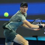 Jannik Sinner of Italy, wearing black nike cap and green shirt, returns a shot ahead of the 2024 Shanghai Masters tennis event