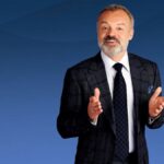 Graham Norton in suit in front of blue background