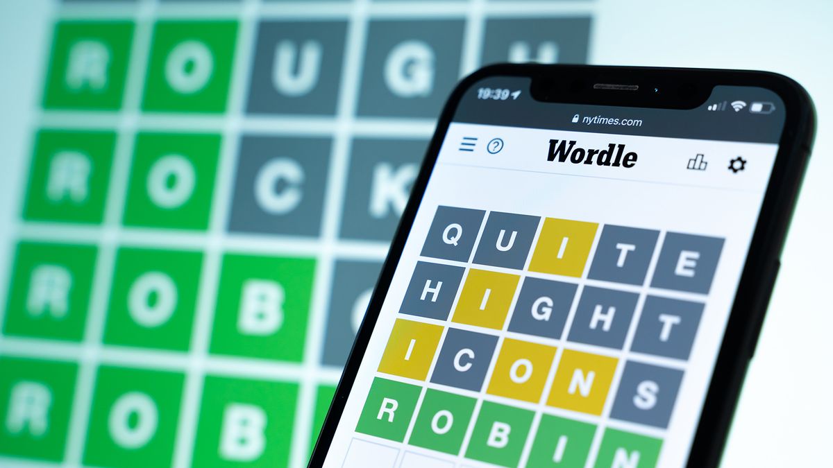 The game Wordle displayed on a smartphone in front of a screen showing another Wordle game