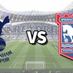 The Tottenham Hotspur and Ipswich Town club badges on top of a photo of Tottenham Hotspur Stadium in London, England