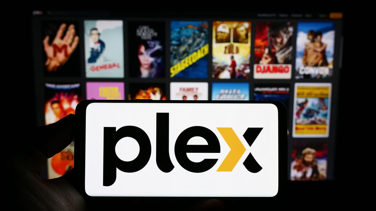 بخور Plex افزایش قیمت می شود و این ویژگی مهم از پشت دیوار پرداخت عبور می کند A phone with the Plex logo in front of an out-of-focus background of movie posters