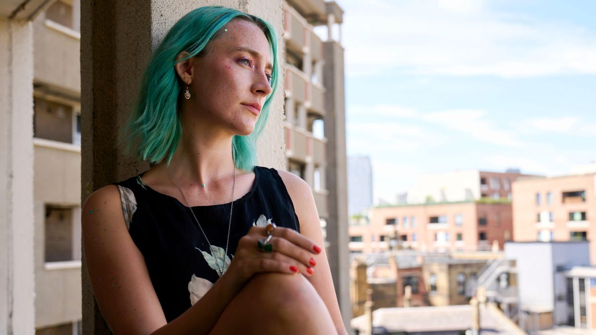 نتفلیکس یکی از فیلم های مورد علاقه من در سال 2024 را دریافت کرد - Saoirse Ronan's Never Better Rona (Saoirse Ronan) leans against a window in "The Outrun"