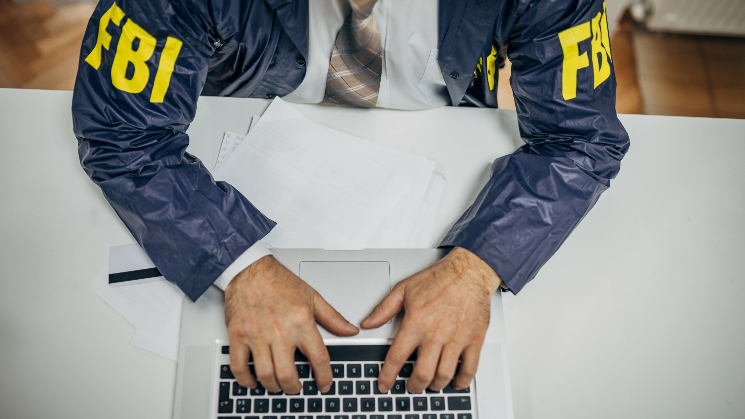 FBI به واسطه ها هشدار می دهد که پول شما را سرقت کنند. An FBI agent typing on a computer